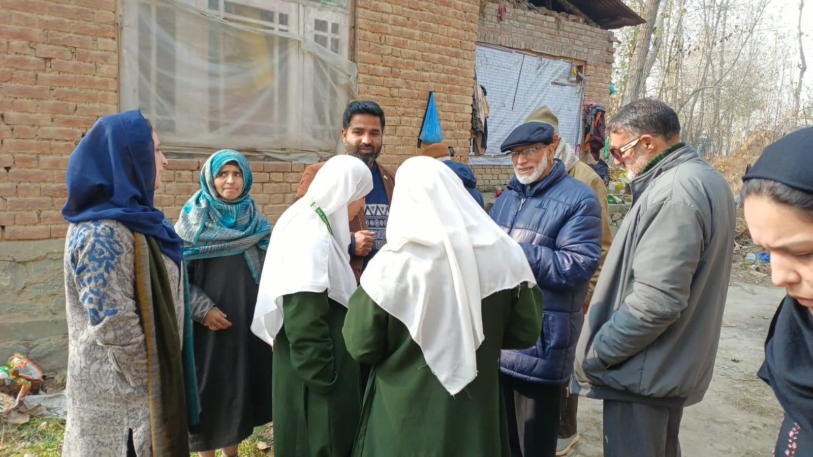 SAWAB team members speaking with residents and students during a field visit